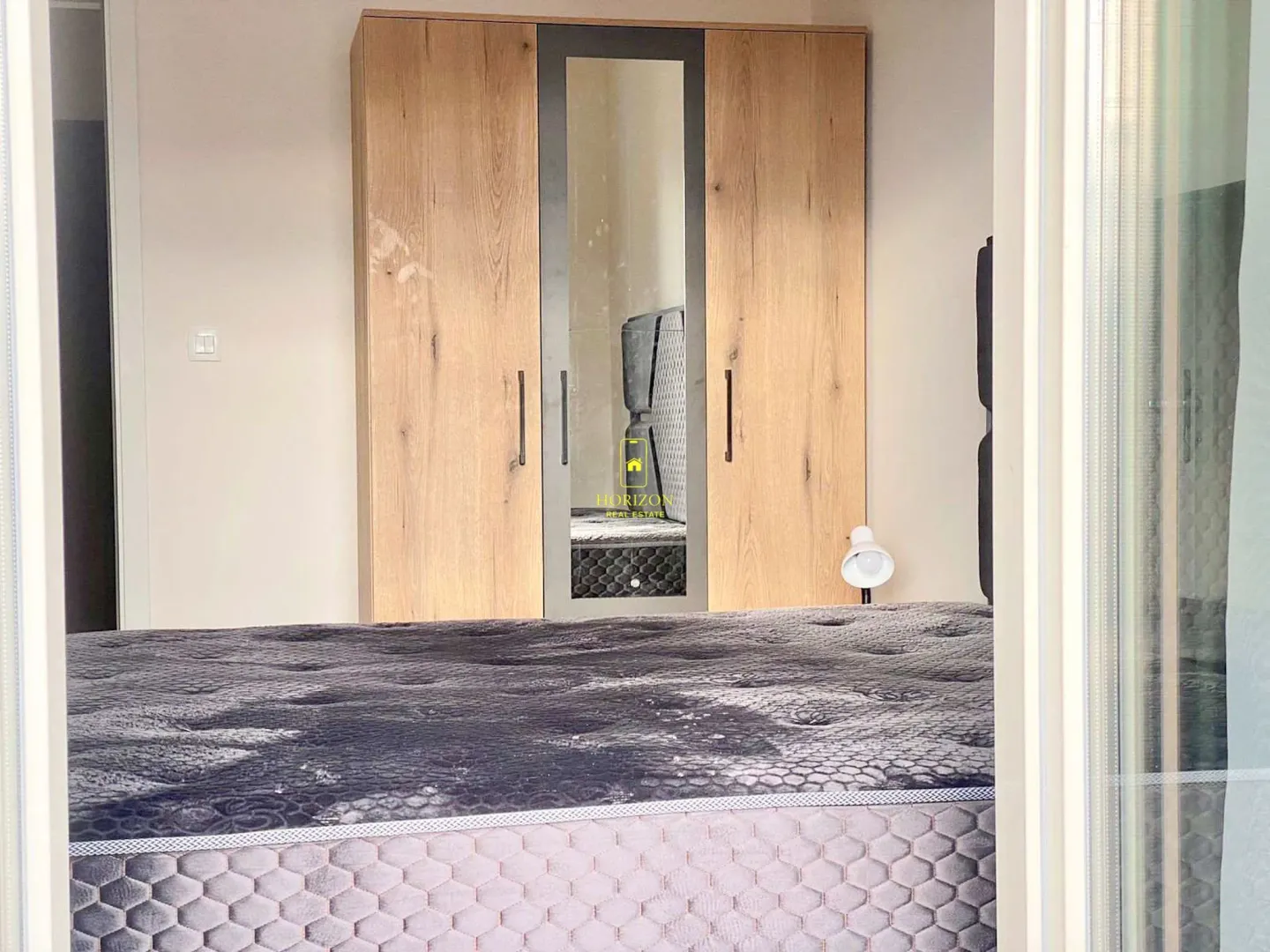 Furnished bedroom with a large wardrobe and bed.