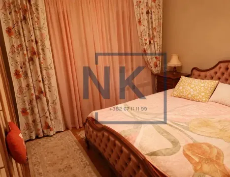 Furnished bedroom with a double bed, bedside table, and a window with curtains. - image 7