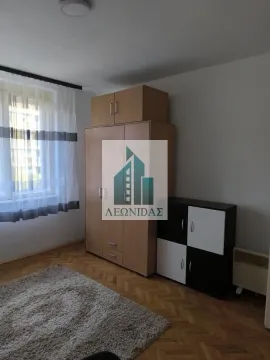 Nameštena spavaća soba sa ormanom, tepihom i prozorom. - image 2
