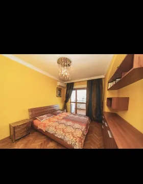 Svijetla spavaća soba sa žutim zidovima i izlazom na balkon. - image 8