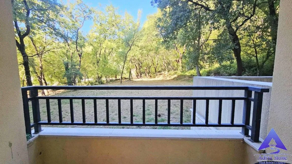 Pogled sa balkona na dvorište i okolnu šumu.