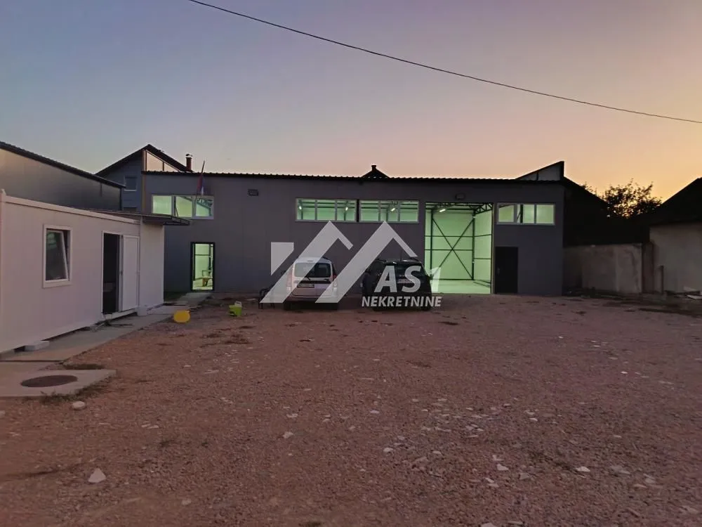 Exterior view of the industrial building with a yard at dusk.