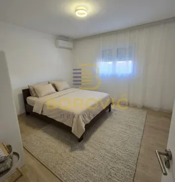 Furnished bedroom with a double bed and a window with curtains. - image 7