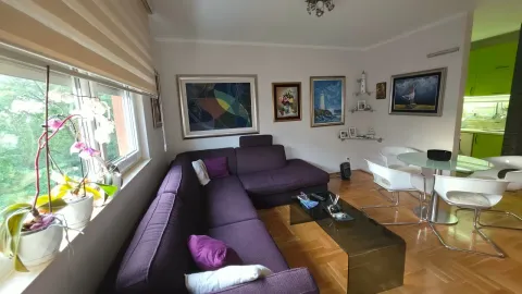 Spacious living room with a sectional sofa, dining table, and green views. - image 2