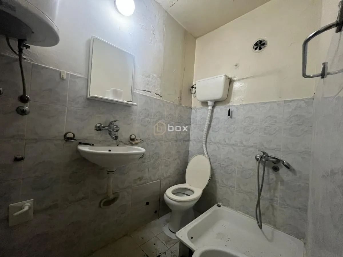 Older equipped bathroom with sanitary fixtures and a shower cabin.