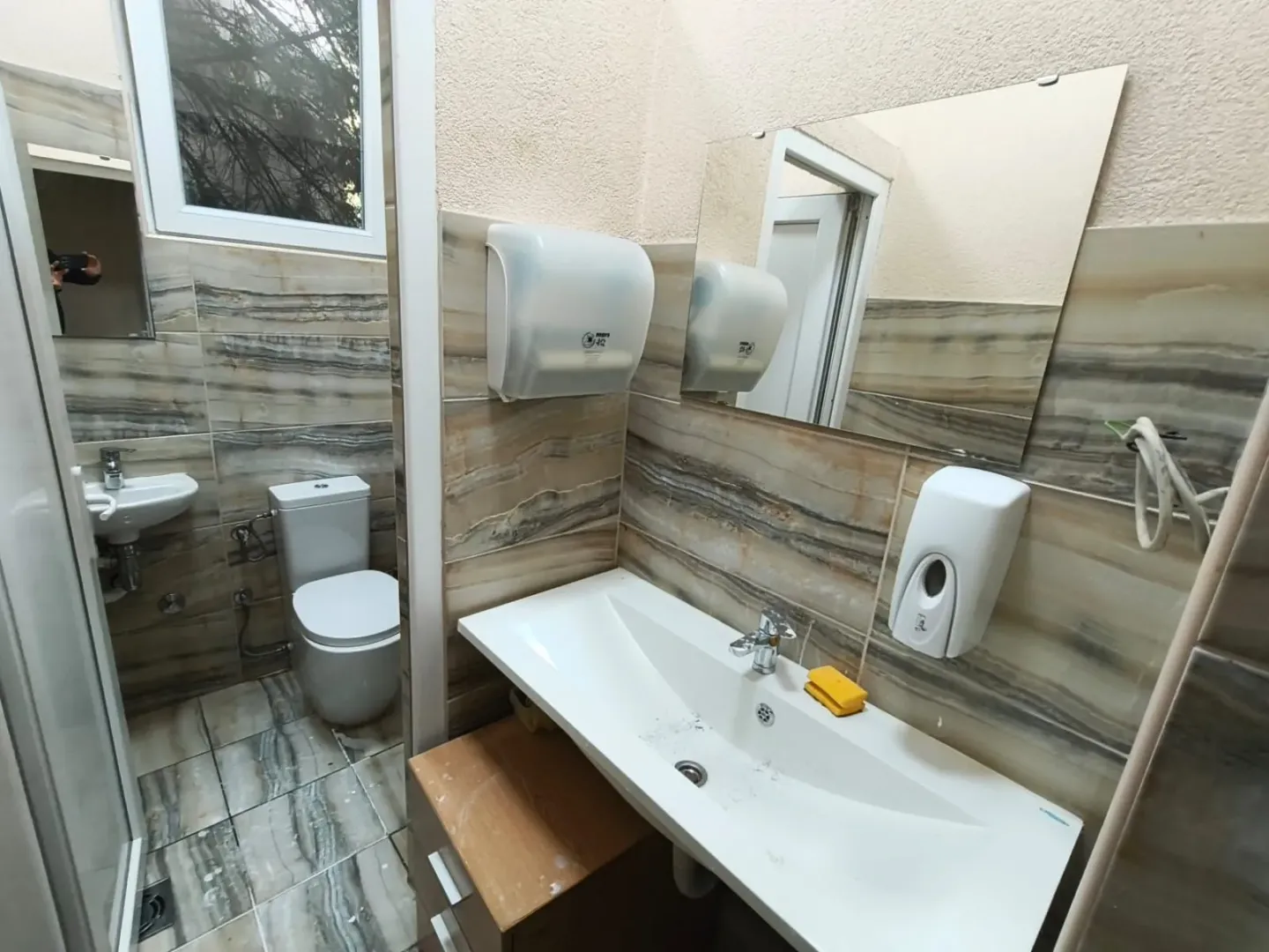 Small bathroom with a sink and toilet in a tiled interior.