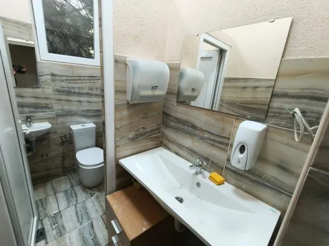 Small bathroom with a sink and toilet in a tiled interior. - image 15