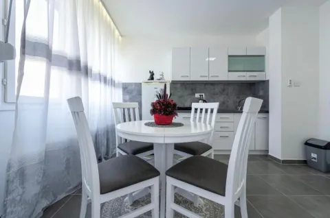 Modern kitchen with dining table and white elements. - image 19