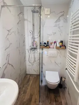 Moderno kupatilo sa tuš kabinom obloženom pločicama sa dezenom mermera i WC šoljom. - image 16