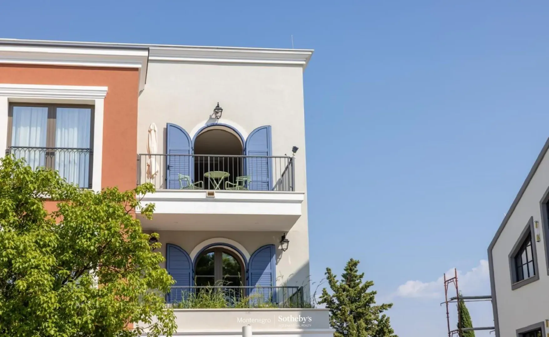 Pogled na spoljašnjost zgrade sa terasama i plavim kapcima.