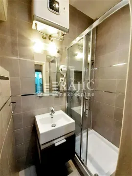 Small equipped bathroom with a shower cabin and a washbasin. - image 11