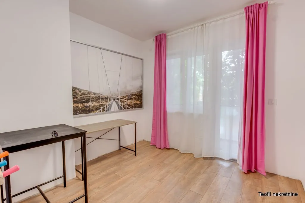Room with a desk and a large picture on the wall.