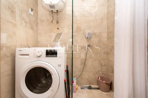 Bathroom with a shower cabin and a washing machine. - image 7