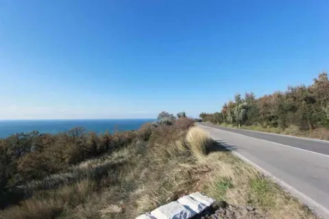 Pogled na asfaltirani put pored obale mora i prirodno okruženje. - image 3