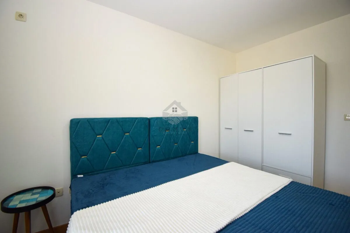Bedroom with a double bed and a white wardrobe.