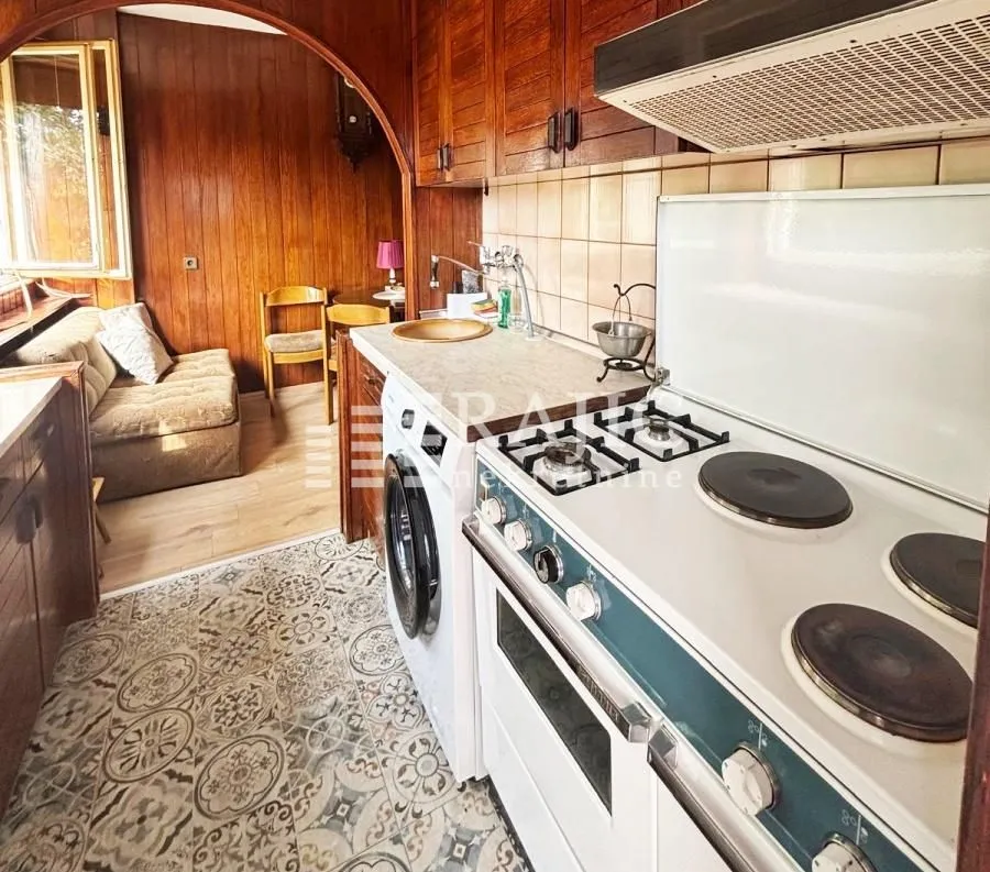 Small kitchen with a stove and a washing machine.