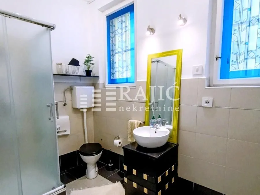 Small bathroom with a sink, toilet, and shower cabin.
