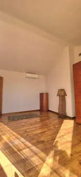 Bright bedroom with wooden flooring, a wardrobe, and an air conditioning unit. - image 10