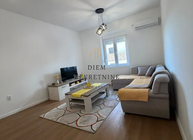 Living room with a corner sofa, TV, and coffee table.
