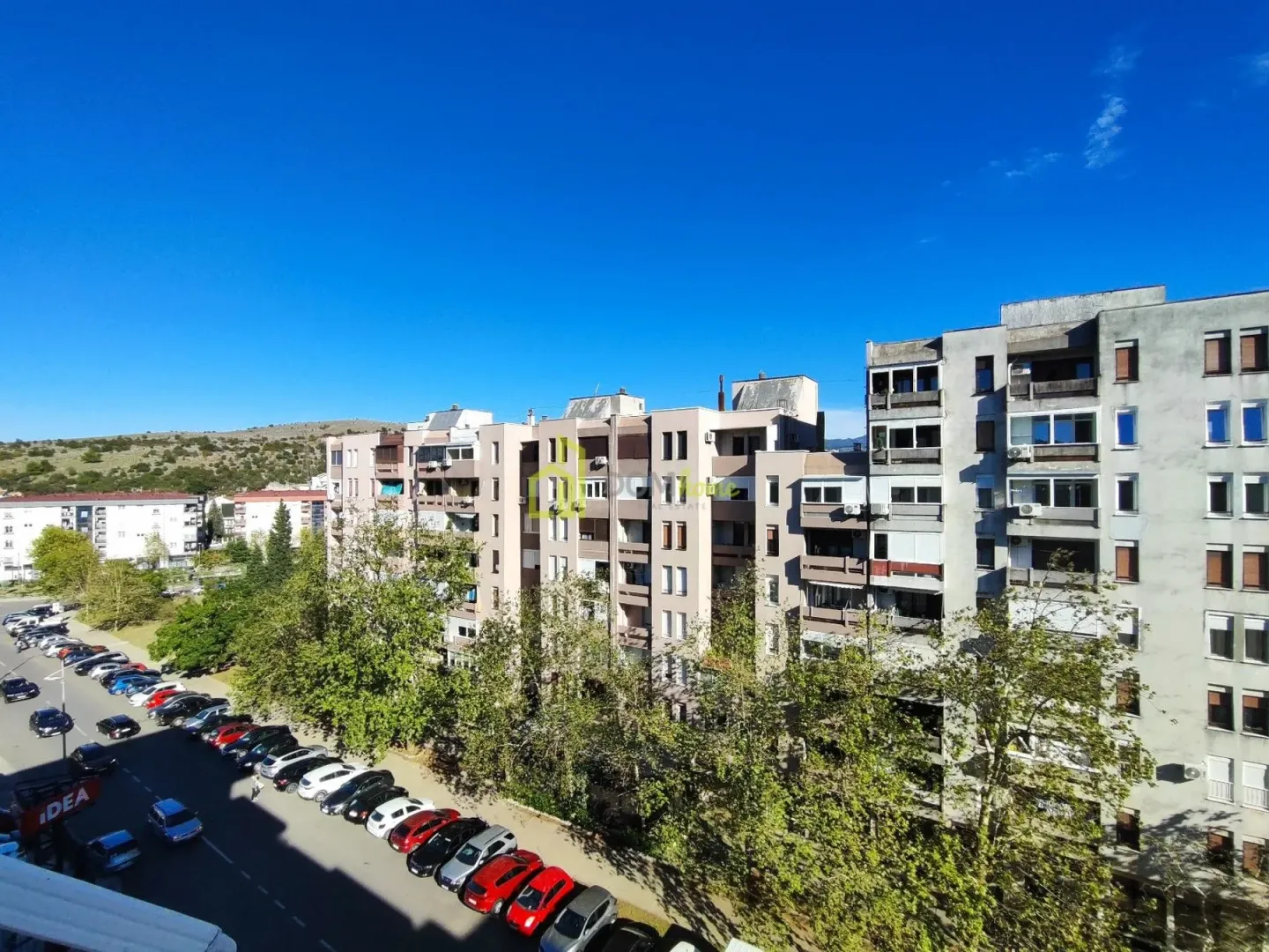 View from the window overlooking surrounding buildings, parking lot, and street.