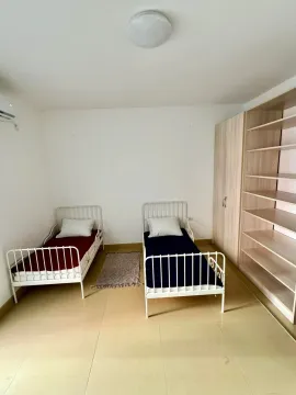 Bedroom with two single beds and a wardrobe. - image 9