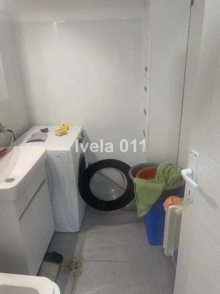 Manje kupatilo sa umivaonikom i veš mašinom.