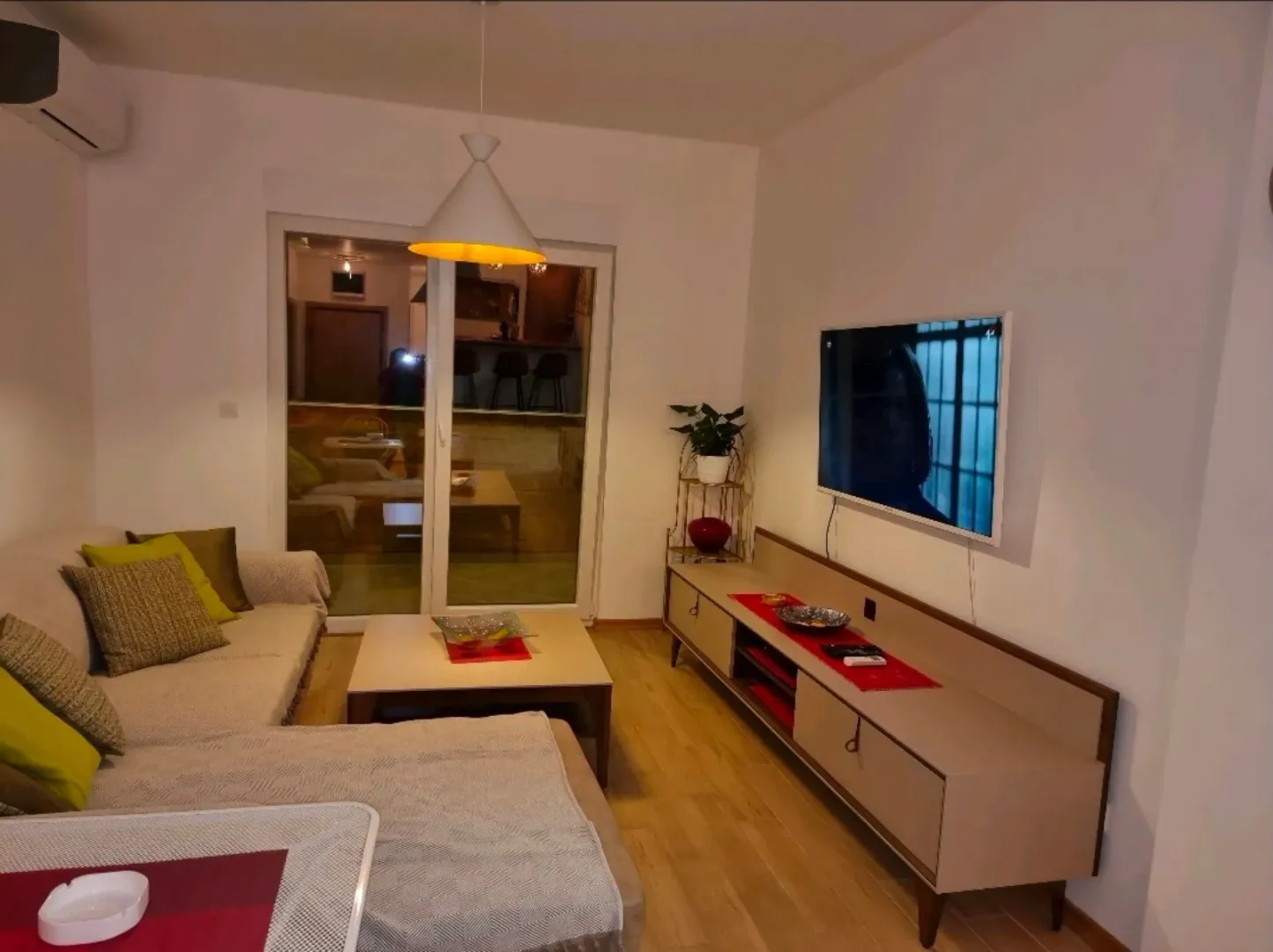 Furnished living room with a sofa set, TV unit, and access to the terrace.