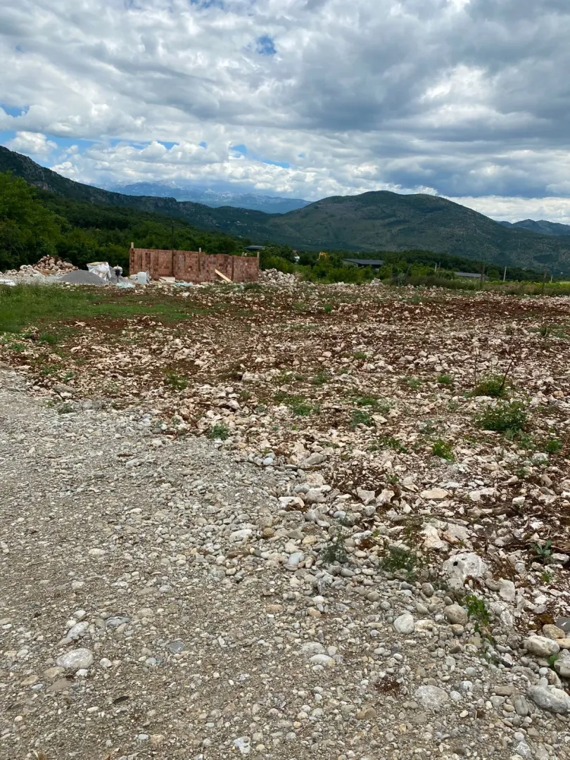 Pogled na plac sa započetom gradnjom i planinskim pejzažem u pozadini.