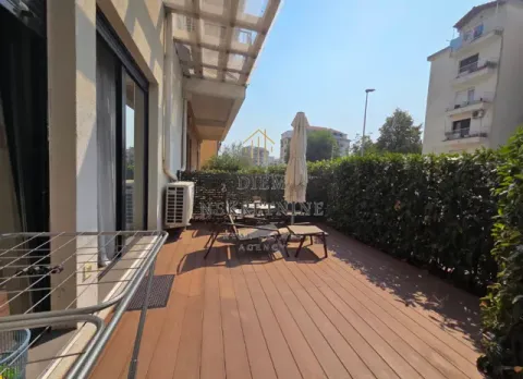 Spacious terrace with wooden flooring and outdoor seating furniture. - image 13