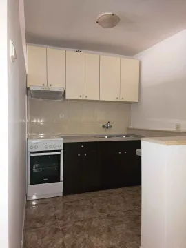 Small kitchen with two-tone cabinets and a stove. - image 4