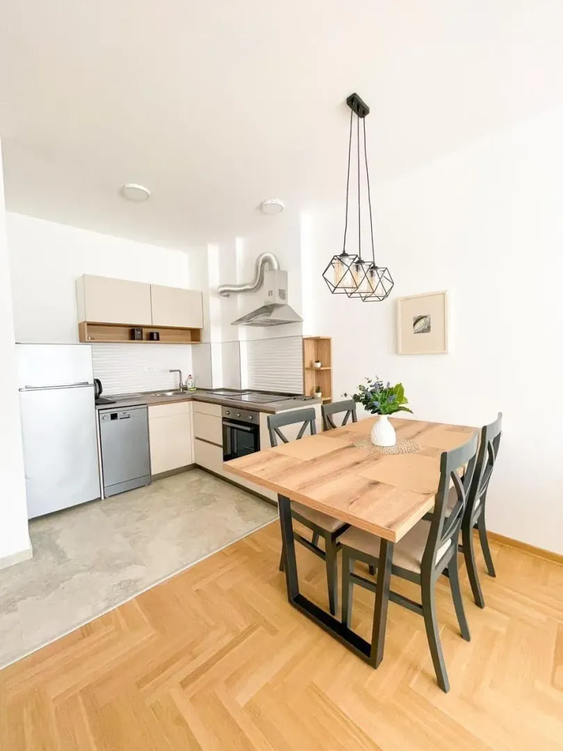 Kitchen with dining area and a wooden table.