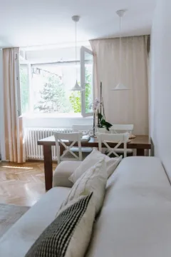 Dnevna soba sa garniturom i trpezarijskim stolom pored prozora. - image 4