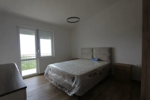 A bedroom featuring a new double bed with plastic wrap and balcony access. - image 13