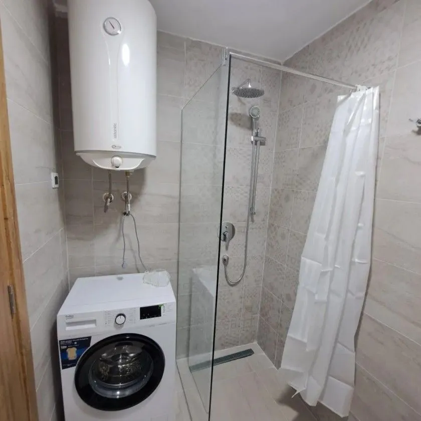 Moderno opremljeno kupatilo sa tuš kabinom, bojlerom i veš mašinom.