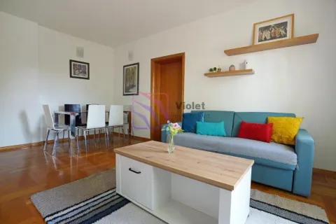 Living room with a sofa, coffee table, and a dining table with chairs. - image 2