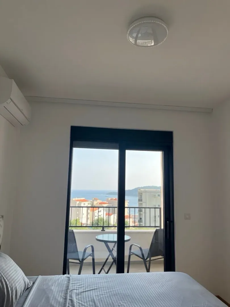 Bedroom with a double bed and a sea view through the balcony door.