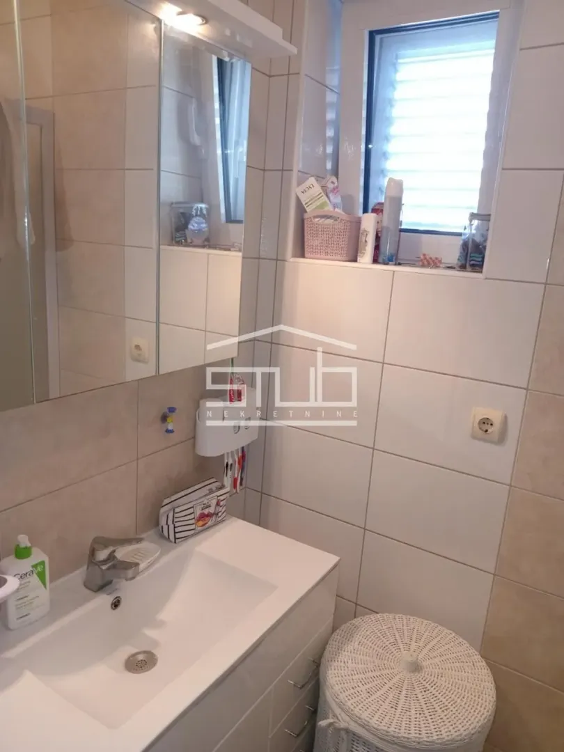 Smaller bathroom with a washbasin, mirror, and window.