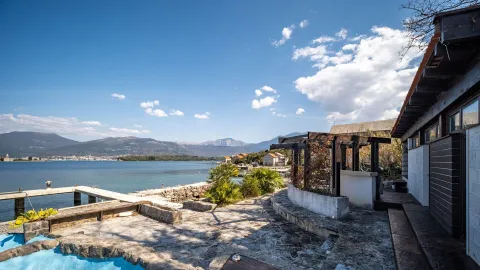 Eksterijer nekretnine sa popločanim dvorištem, terasom i pogledom na more i planine. - image 4