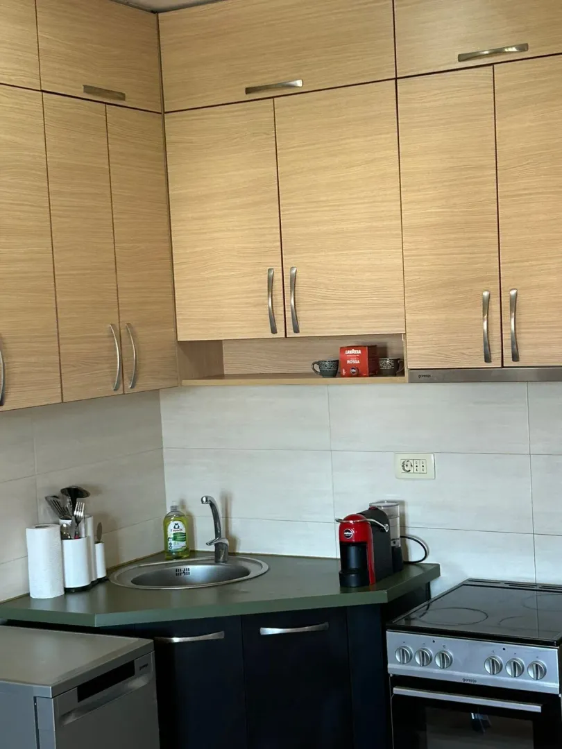 Kitchen with wooden cabinetry, a sink, and a coffee machine.