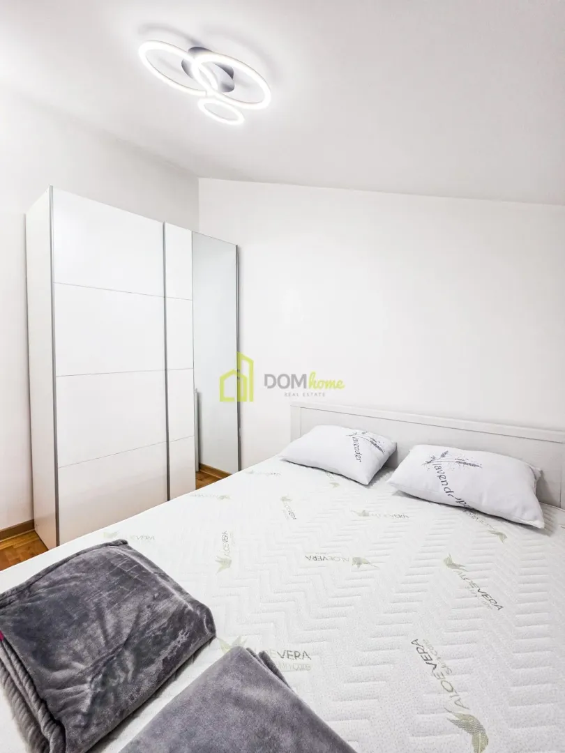 Bedroom with a double bed, white wardrobe, and modern ceiling light.