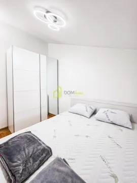 Bedroom with a double bed, white wardrobe, and modern ceiling light. - image 7