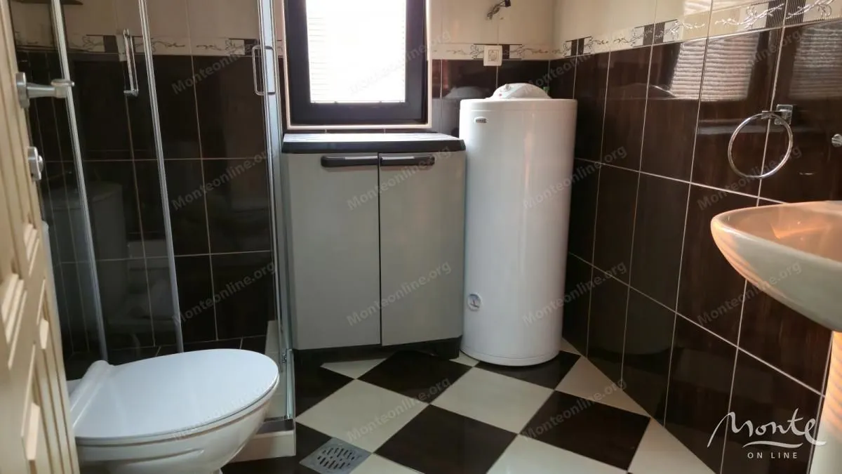 Kupatilo opremljeno tuš kabinom, umivaonikom, wc šoljom i bojlerom.