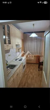 Manja kuhinja sa svetlim drvenim elementima i trpezarijskim delom kod prozora. - image 3