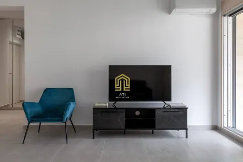 Dnevna soba sa televizorom, plavom foteljom i komodom. - image 8