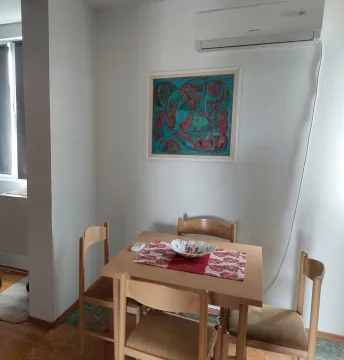 Smaller wooden dining table with four chairs and a painting on the wall. - image 3