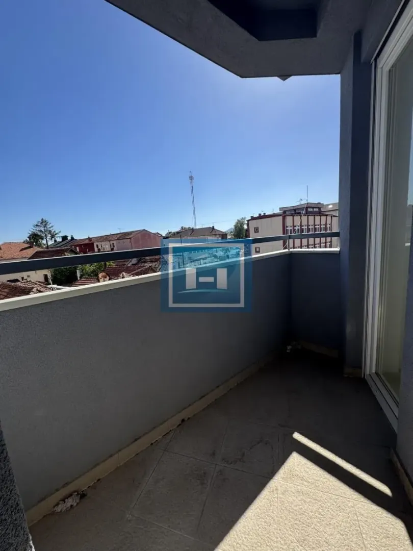 Manji natkriveni balkon sa pogledom na naselje i krovove kuća.