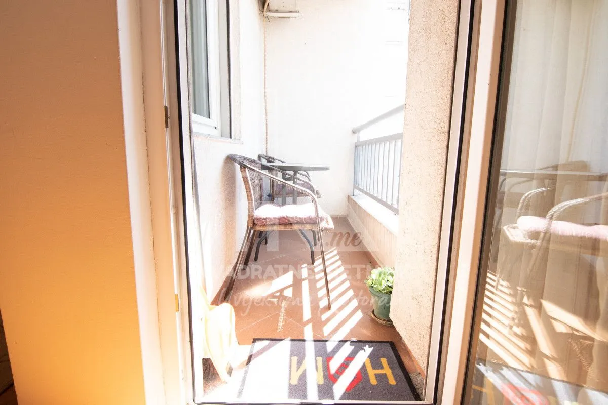 Manji namješteni balkon sa stolom i stolicama.