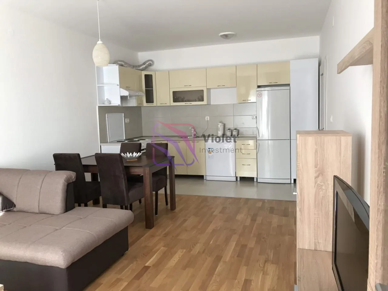 Living room with dining area and kitchen in an open-plan space.