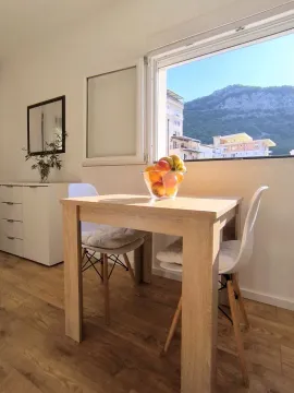 Dining table with chairs and a mountain view through the window. - image 5