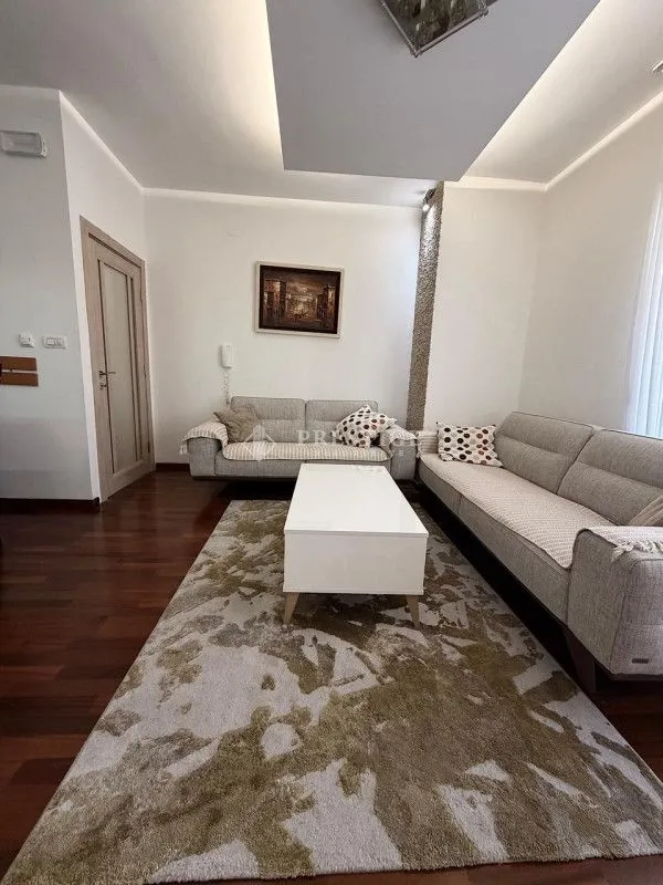 Living room with sofa set, coffee table and rug.